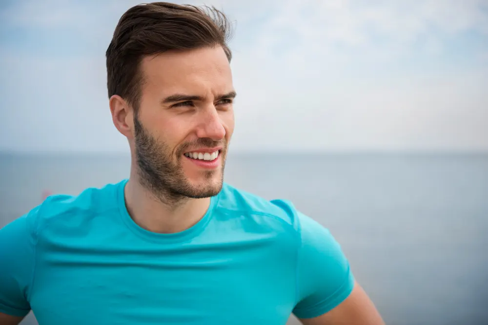 close up young fit person jogging by sea